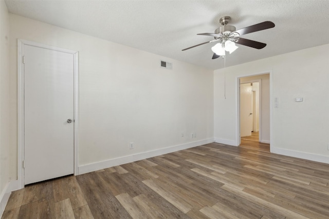 spare room with ceiling fan, hardwood / wood-style floors, and a textured ceiling