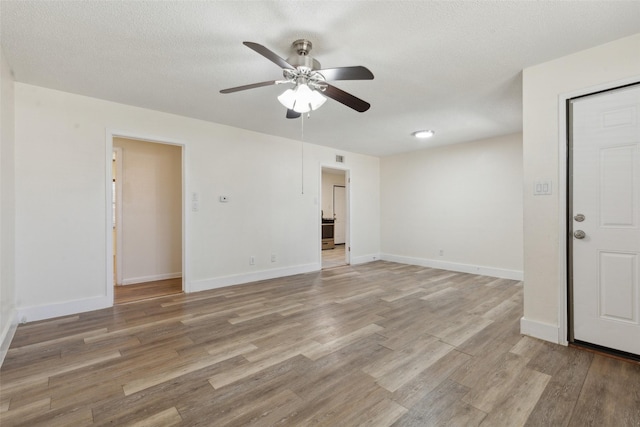 unfurnished room featuring ceiling fan, light hardwood / wood-style flooring, and a textured ceiling