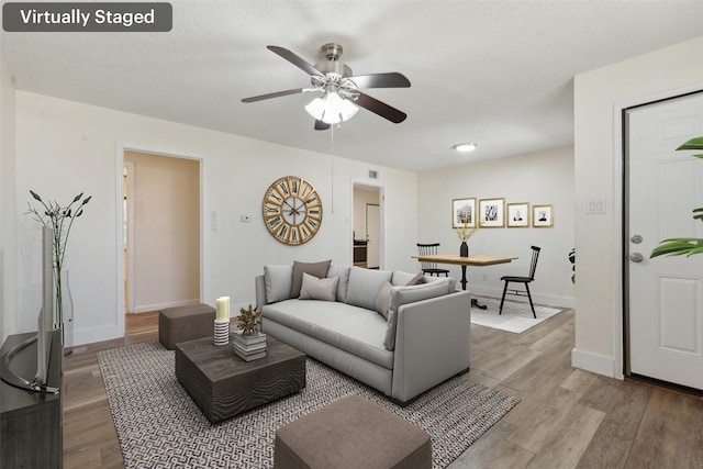 living room featuring ceiling fan and wood-type flooring