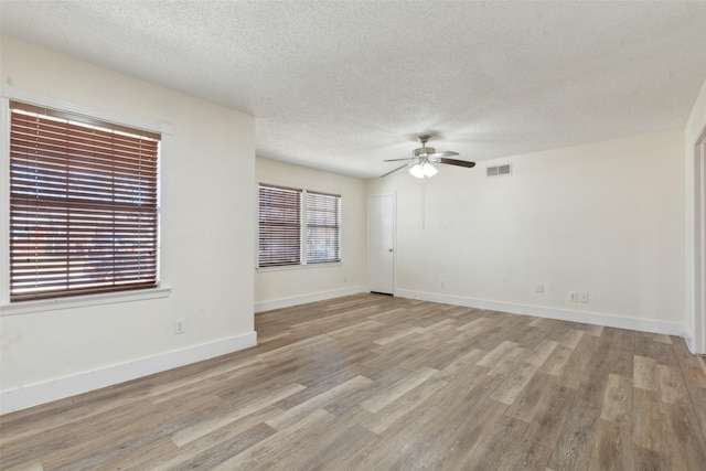 spare room with ceiling fan, light hardwood / wood-style flooring, and a textured ceiling