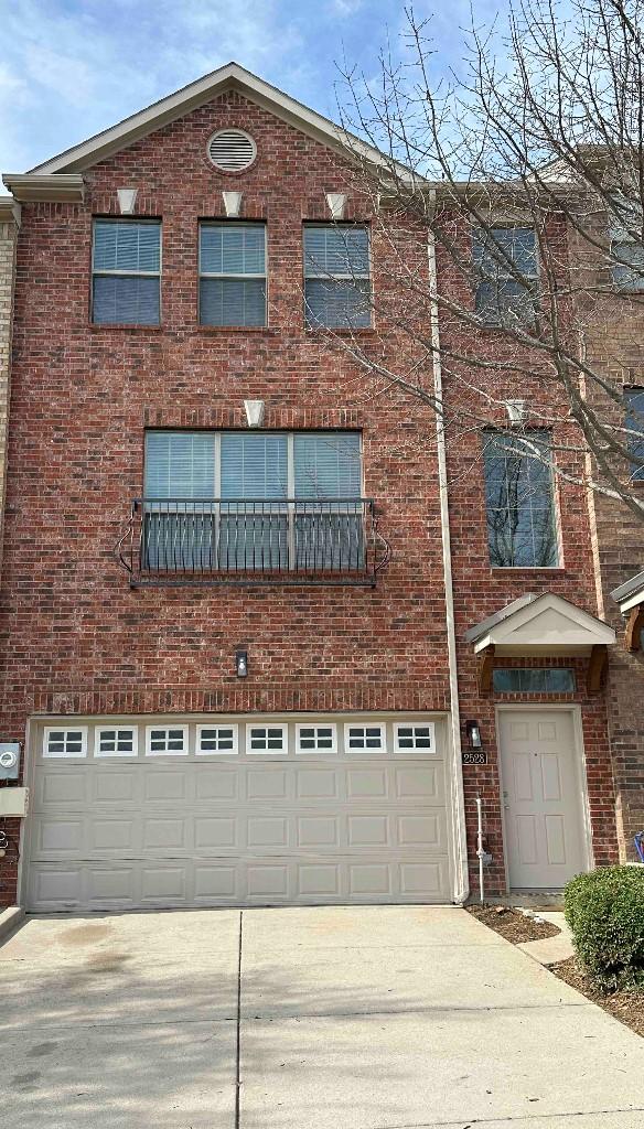 view of front of property featuring a garage, brick siding, and driveway