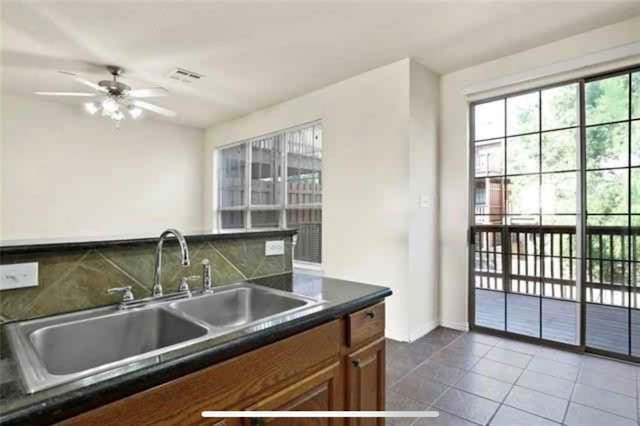 kitchen featuring sink, dark tile patterned flooring, ceiling fan, and decorative backsplash