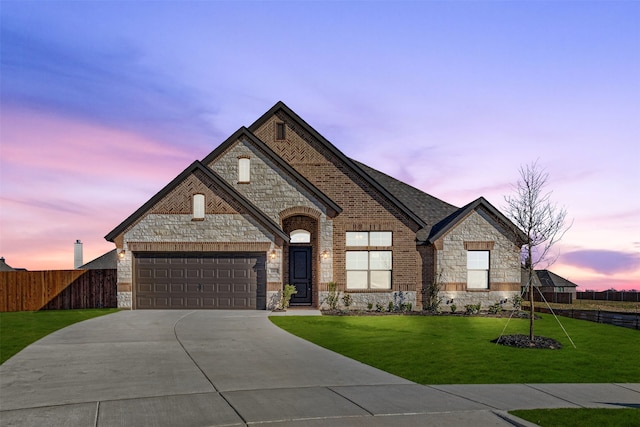 view of front of property featuring a garage and a lawn