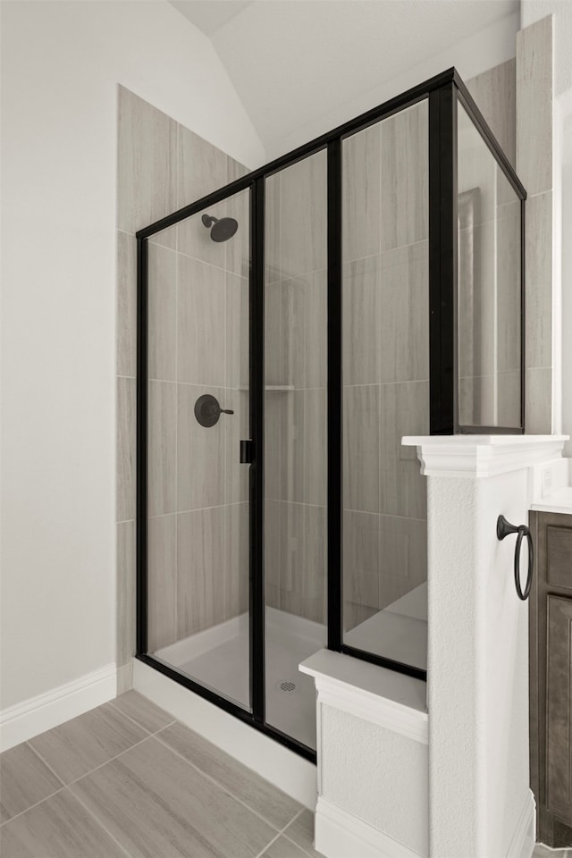 bathroom with lofted ceiling, an enclosed shower, and vanity