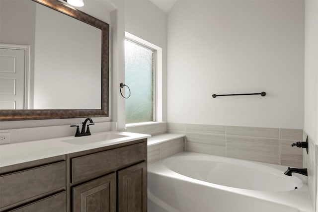 bathroom with a wealth of natural light, a bath, and vanity