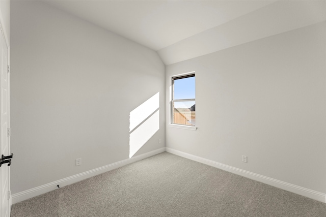 carpeted spare room featuring lofted ceiling