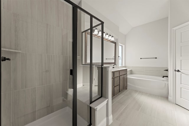 bathroom featuring independent shower and bath, vanity, vaulted ceiling, and tile patterned floors