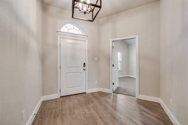 entryway featuring a notable chandelier, a wealth of natural light, and light wood-type flooring