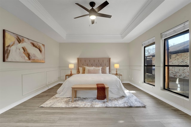 bedroom featuring hardwood / wood-style floors, a tray ceiling, and ceiling fan