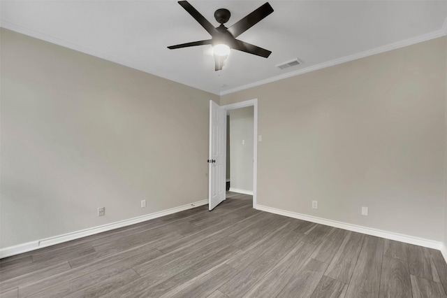 spare room featuring hardwood / wood-style flooring, ornamental molding, and ceiling fan