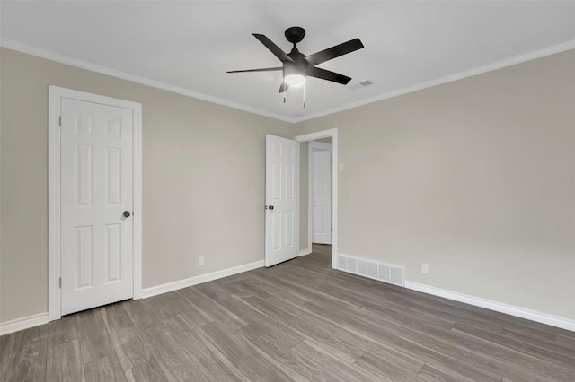 empty room featuring hardwood / wood-style flooring, ceiling fan, and crown molding