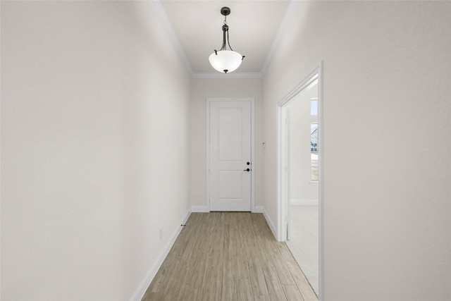 entryway with ornamental molding and light hardwood / wood-style floors