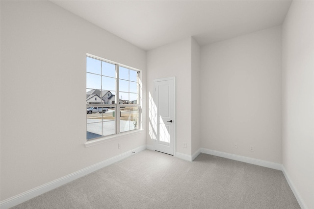 unfurnished room featuring light colored carpet