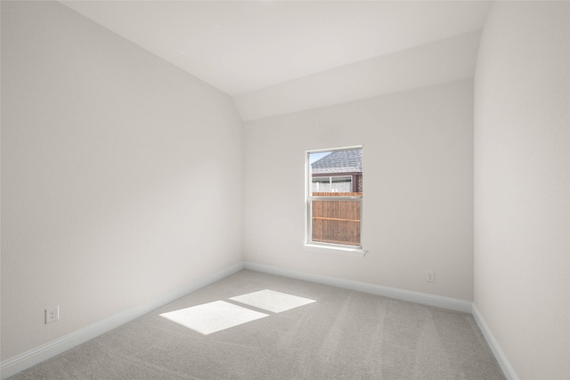 unfurnished room with lofted ceiling and light colored carpet