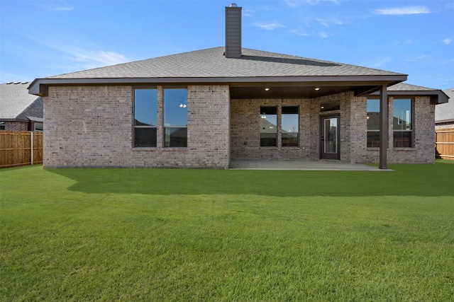 rear view of property featuring a yard and a patio area