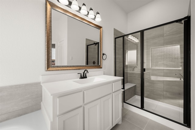 bathroom with a shower with door, vanity, and tile patterned floors