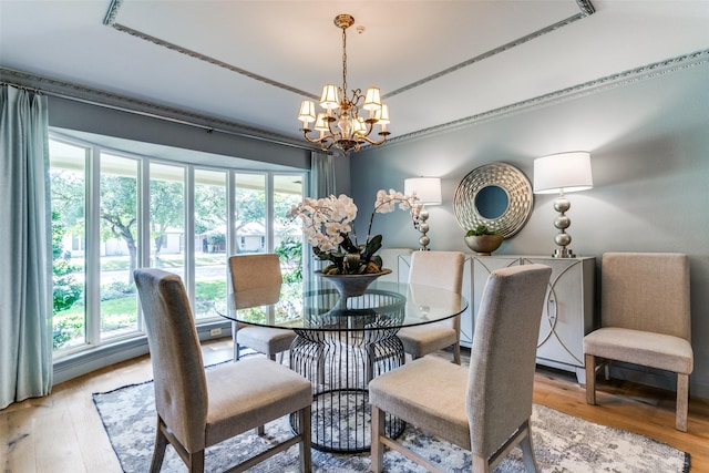 dining space with a notable chandelier, crown molding, and light hardwood / wood-style floors