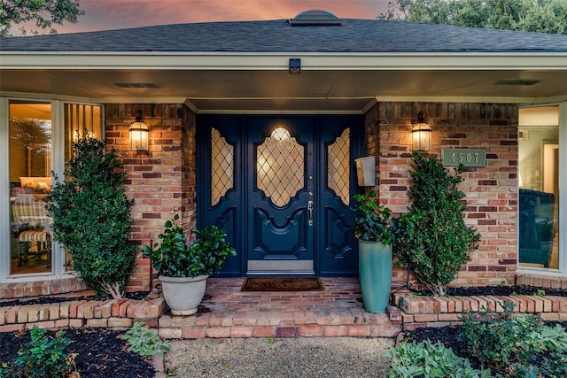 exterior entry at dusk featuring a porch