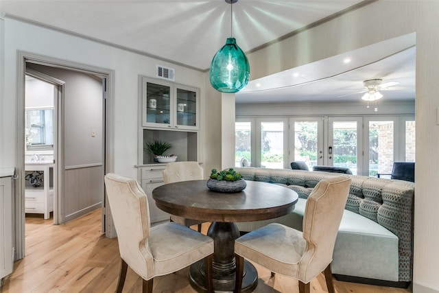 dining space with ceiling fan, ornamental molding, light hardwood / wood-style floors, and a healthy amount of sunlight