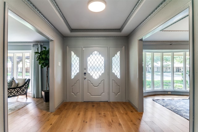 foyer featuring a tray ceiling and light wood-type flooring