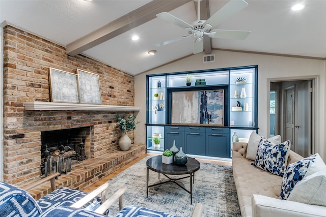 living room featuring a brick fireplace, lofted ceiling with beams, hardwood / wood-style floors, and ceiling fan