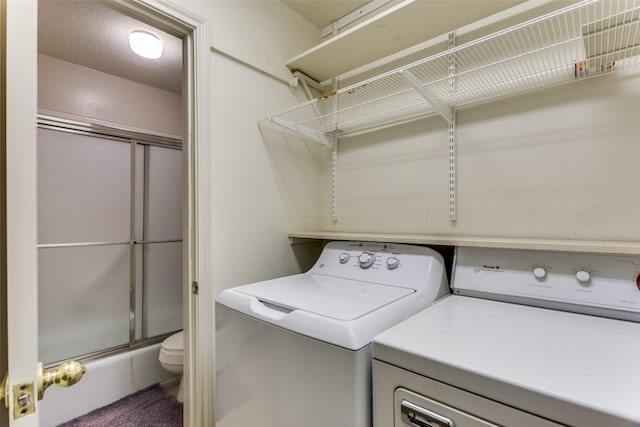 clothes washing area with a textured ceiling and washing machine and clothes dryer