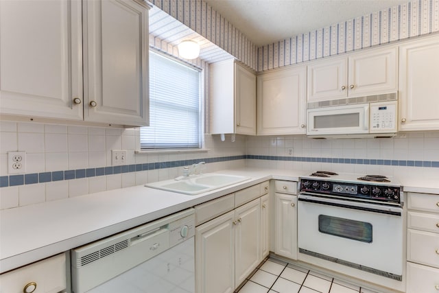 kitchen with tasteful backsplash, white appliances, sink, and light tile patterned floors