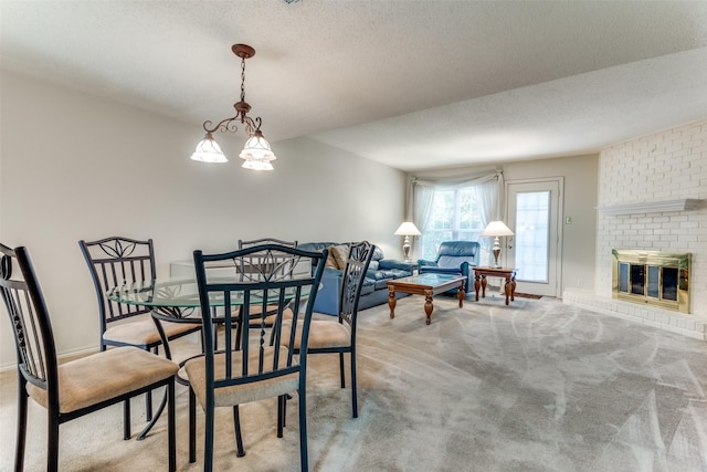 dining area with light carpet, a fireplace, and a textured ceiling