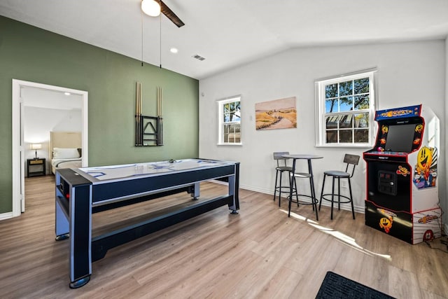 recreation room with lofted ceiling, wood finished floors, visible vents, and baseboards