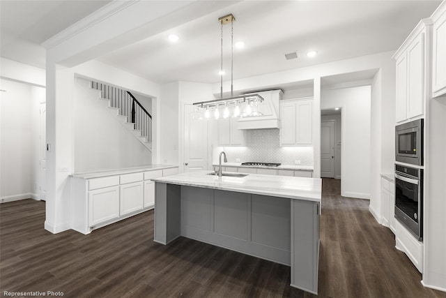 kitchen featuring a sink, backsplash, stainless steel appliances, white cabinetry, and dark wood-style flooring