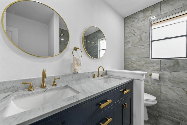 bathroom with vanity, tile walls, and toilet