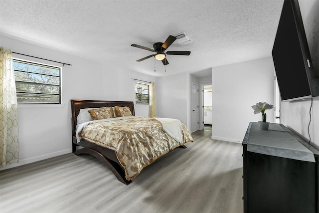 bedroom with light wood-type flooring, a textured ceiling, and ceiling fan