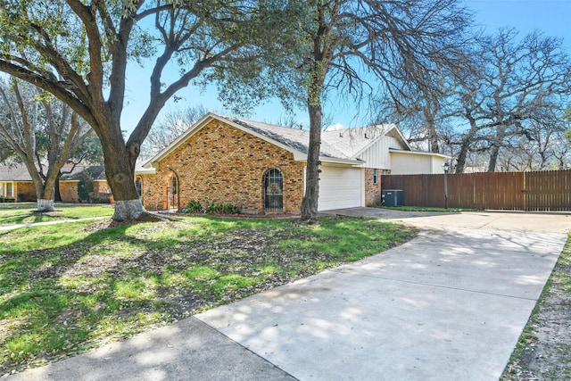 single story home featuring cooling unit and a garage