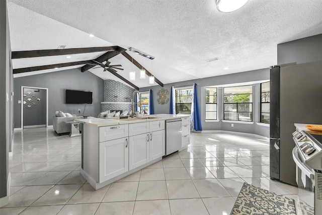 kitchen with sink, white cabinetry, vaulted ceiling with beams, stainless steel appliances, and a center island with sink