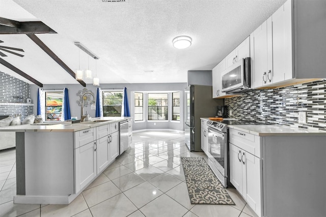 kitchen featuring pendant lighting, sink, backsplash, stainless steel appliances, and white cabinets