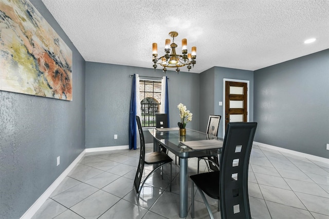 tiled dining area with a notable chandelier and a textured ceiling