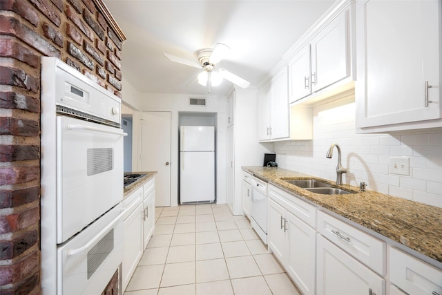 kitchen with brick wall, stone countertops, white cabinetry, sink, and white appliances