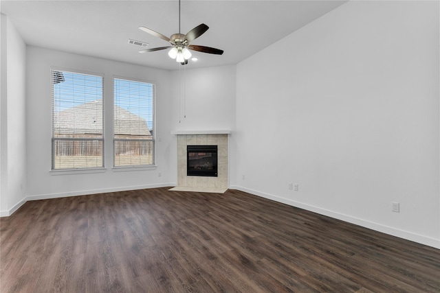 unfurnished living room with ceiling fan, dark wood-type flooring, and a fireplace