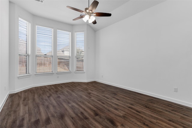 spare room with dark hardwood / wood-style flooring, vaulted ceiling, and ceiling fan