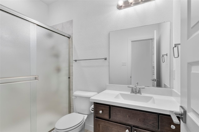 bathroom with vanity, toilet, and a shower with shower door