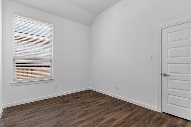 unfurnished room with vaulted ceiling and dark wood-type flooring