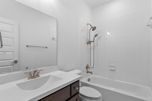 full bathroom with tiled shower / bath, vanity, and toilet