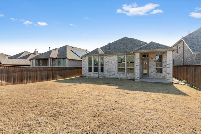 rear view of property with a patio and a yard