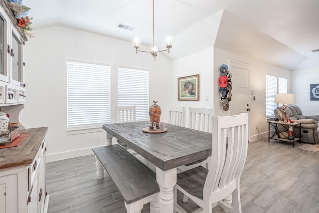 dining room with an inviting chandelier and vaulted ceiling