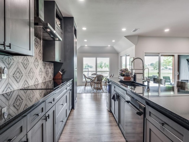 kitchen with sink, gray cabinetry, stainless steel dishwasher, a healthy amount of sunlight, and wall chimney range hood