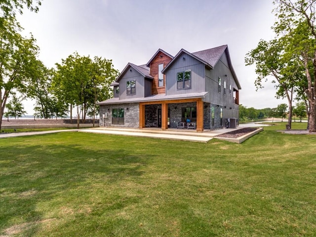 rear view of property featuring cooling unit, a lawn, and a patio