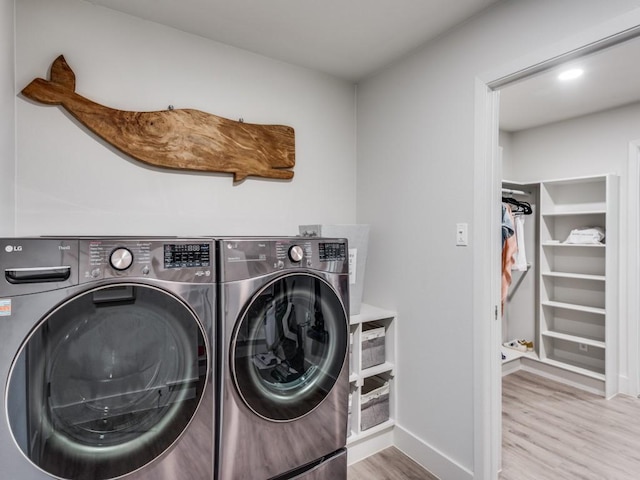 laundry area with washer and clothes dryer and light hardwood / wood-style floors