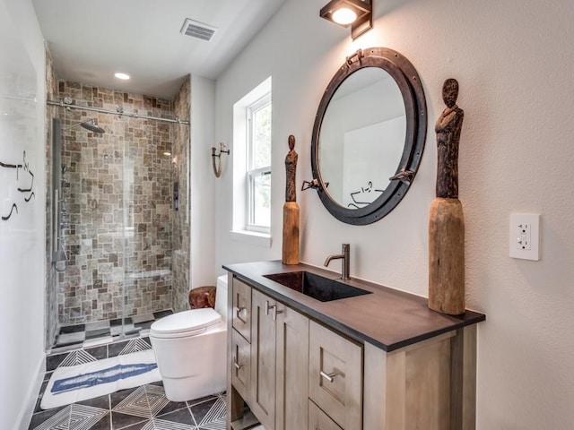 bathroom with vanity, tiled shower, and toilet