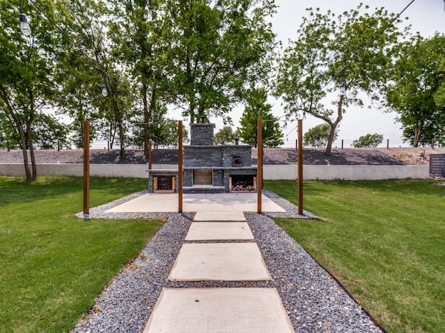 view of yard featuring a patio area and an outdoor fireplace