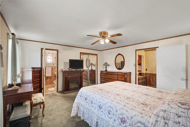 carpeted bedroom with ceiling fan, ensuite bath, crown molding, and a closet